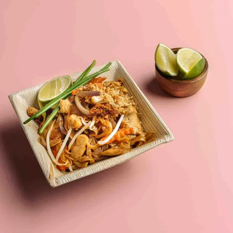 Pad thai with lime in a bamboo bowl