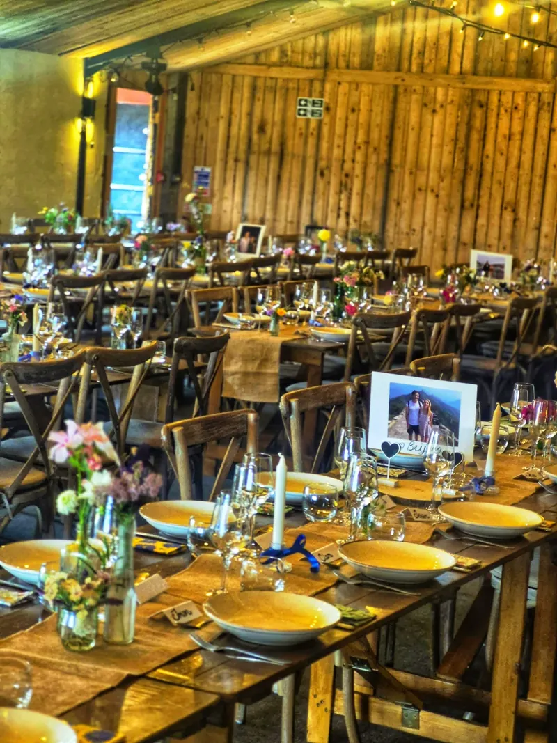 Barn wedding tables laid for dinner