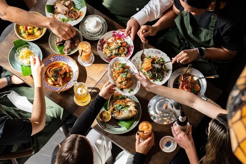 Guests sharing Thai dishes at a private party